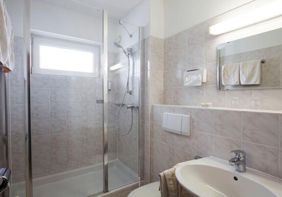Ein Badezimmer mit Dusche und WC in den Zimmern des Hotel Agathawirt