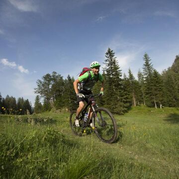 Ein Mann fährt mit dem Mountainbike in der Wiese