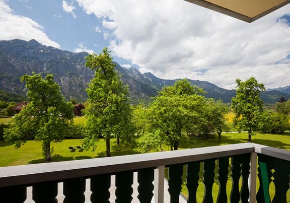 Vom Balkon aus hat man einen beeindruckenden Blick auf den grünen Garten und die Berge des Salzkammergutes