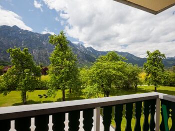 Vom Balkon aus hat man einen beeindruckenden Blick auf den grünen Garten und die Berge des Salzkammergutes
