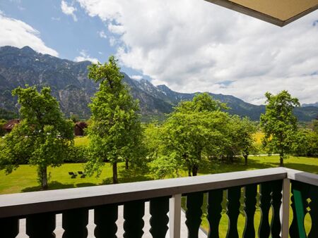 Vom Balkon aus hat man einen beeindruckenden Blick auf den grünen Garten und die Berge des Salzkammergutes