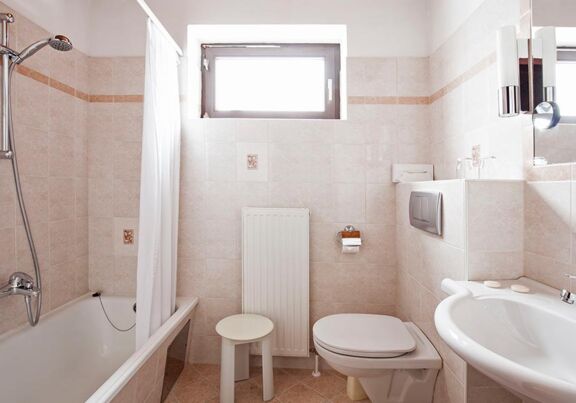 Ein helles Badezimmer mit Badewanne im Landhotel Agathawirt