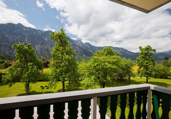 Vom Balkon aus hat man einen beeindruckenden Blick auf den grünen Garten und die Berge des Salzkammergutes