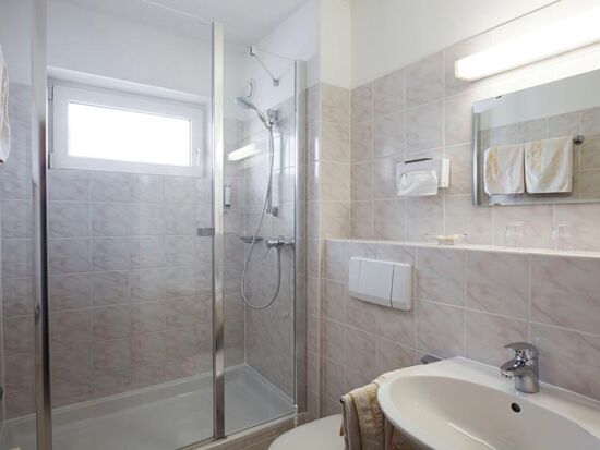 Ein Badezimmer mit Dusche und WC in den Zimmern des Hotel Agathawirt