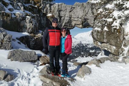 Zwei Wanderer genießen den traumhaften Ausblick durch das Loserfenster