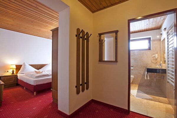 Ein kleiner Vorraum der ins Schlafzimmer mit einem Doppelbett und in ein Badezimmer führt