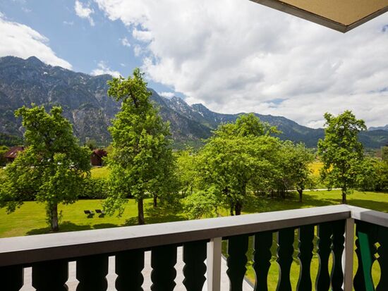 Vom Balkon aus hat man einen beeindruckenden Blick auf den grünen Garten und die Berge des Salzkammergutes
