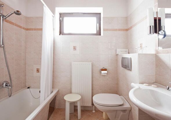 Ein helles Badezimmer mit Badewanne im Landhotel Agathawirt