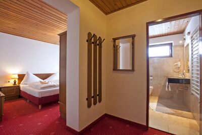 Ein kleiner Vorraum der ins Schlafzimmer mit einem Doppelbett und in ein Badezimmer führt