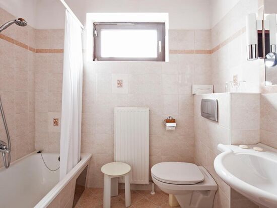 Ein helles Badezimmer mit Badewanne im Landhotel Agathawirt